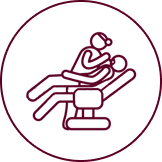 Patient reclined in dental chair receiving examination or treatment from dentist