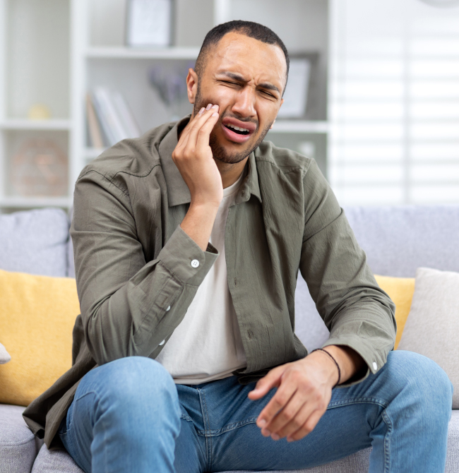 Man smiling while sitting on couch in modern living room setting.