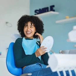 Woman smiling while on phone call in modern dental office reception area