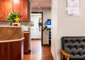 Welcoming dental office reception area with warm wood cabinetry and comfortable seating.