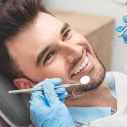 Dentist examining patient's teeth during dental checkup in clinical setting.